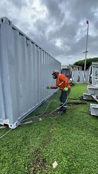 Aplicación de recubrimiento gris en contenedor con equipo de pintura